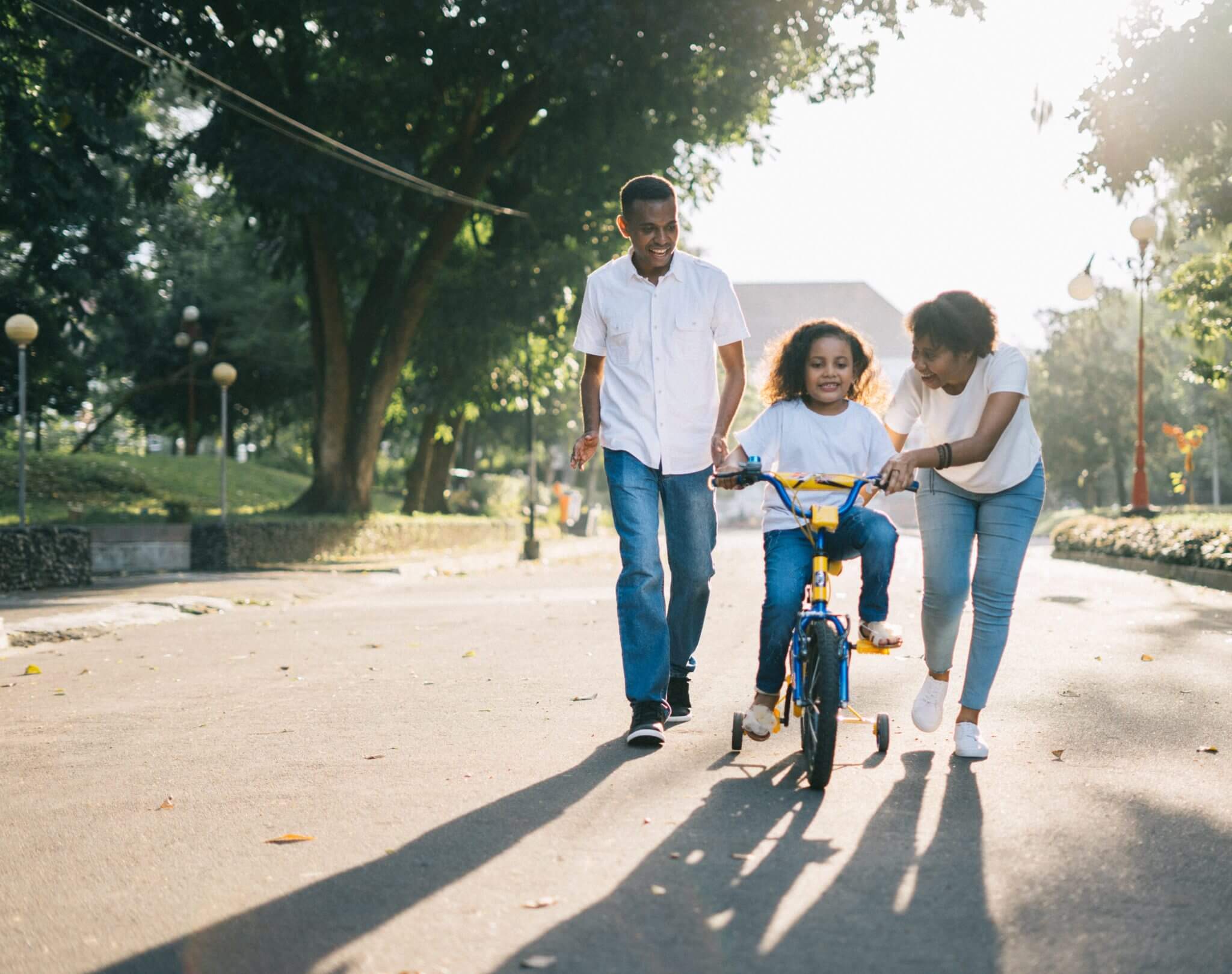 Family learning to ride bike