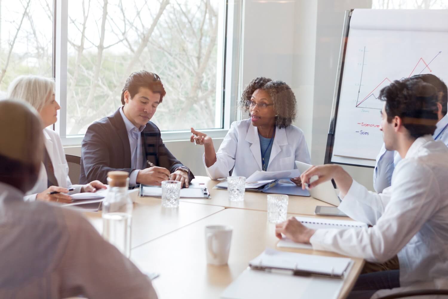 Doctors discussing while sitting at a conference table.